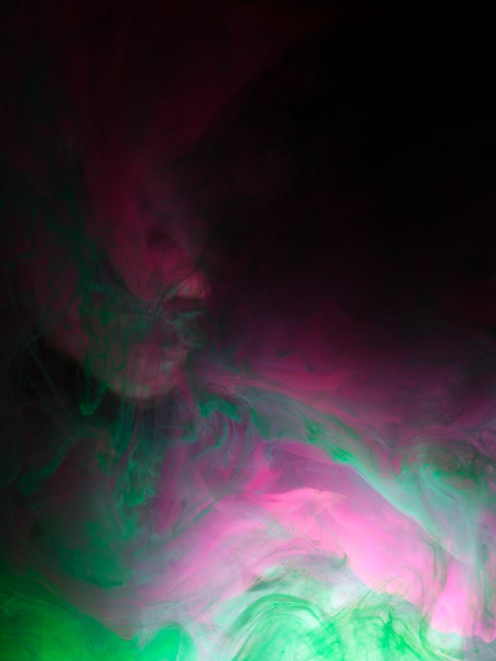 A mesmerizing blend of pink and green watercolors creating swirling abstract patterns.